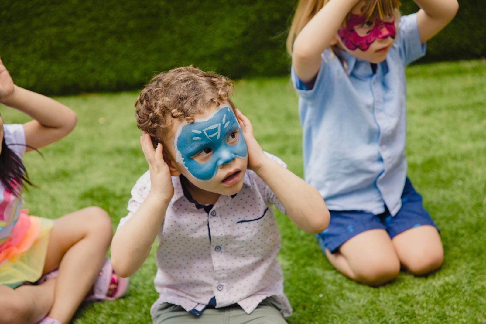 Children with face paint celebrating at an outdoor birthday party