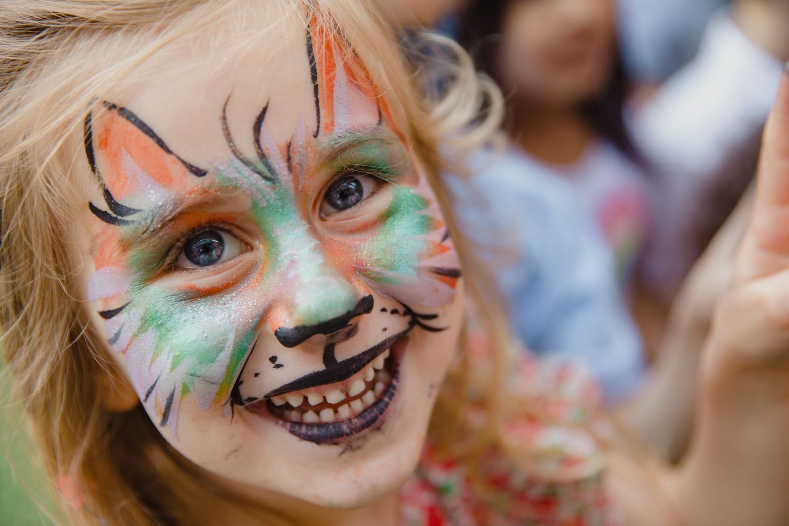 Cheerful girl with animal face paint smiling