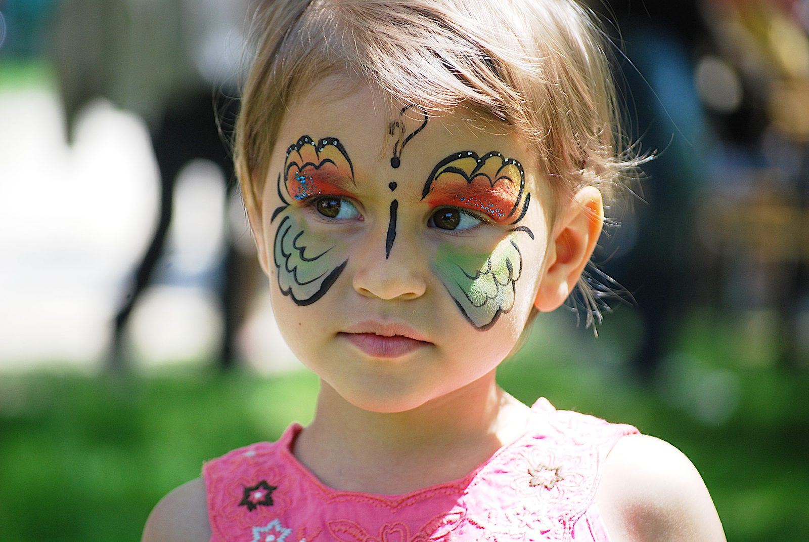 Girl with a colourful butterfly painted across her face